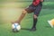 Child feet dribbling and touching Soccer ball on a field