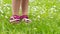 Child feet in grass with daises in spring