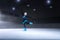 child figure skater on dark ice arena background