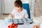 Child filling cupcakes form with dough ingredients