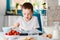 Child filling cupcakes form with dough ingredients