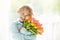 Child with flower bouquet. Mother day greeting