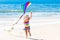 Child flying kite on tropical beach