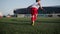 Child footballer is kicking a ball on stadium