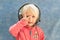 A child in gaming headphones shows a gesture with his fingers