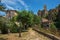 Child in a garden with trees, houses and cliff in Chateaudouble