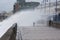 A child gets soaked by a huge wave at Porthcawl, South Wales, UK.