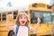 Child getting on school bus. Child with positive gesture with hand, thumbs up smiling and happy. Home education.