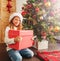 Child with gift near christmas tree