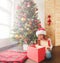 Child with gift near christmas tree