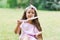 Child girl in an amusement park in the summer eats cotton candy and smiles happily. The concept of summer holidays and school holi