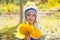 Child girl in autumn poplar forest yellow fall leaves in hand