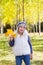 Child girl in autumn poplar forest yellow fall leaves in hand