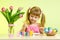 Child girl with brush coloring easter eggs