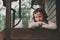 Child girl with candle holder relaxing in evening at cozy country house.