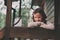 Child girl with candle holder relaxing in evening at cozy country house.