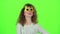 Child girl dancing in funny glasses. Green screen