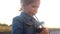 Child girl drinking cocktail, juice, smoothies. Portrait closeup baby at sunset on a summer day