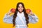 Child girl eating an apple over isolated yellow studio background. Tennager with fruit. Portrait of happy funny smiling