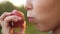 Child Girl Eating Organic Apple in the Garden. Harvest Concept. Close up