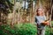 Child girl exploring nature in early spring forest. Kids learning to love nature. Teaching children about seasons changing.