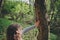 Child girl exploring nature in early spring forest. Kids learning to love nature. Teaching children about seasons changing.