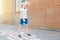 Child girl in face mask playing jumping hopscotch on school yard. Funny activity game for kids on playground outdoors. Street