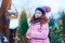 Child girl feeding birds in winter. Bird feeder in snowy garden, helping birds during cold season