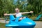 Child girl fly on blue plane attraction in city park, happy childhood, summer vacation concept