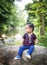 Child girl gaze sitting on a rock