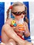 Child girl in glasses and red bikini drink juice.