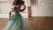 Child girl in a green dress poses in front of a photographer