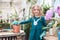 A child girl in a green dress transplants potted flowers in the winter garden. Girl in gardening help transplant flowers