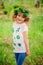 Child girl in handmade wreath and shirt with leaf prints, summer nature craft concept