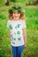 Child girl in handmade wreath and shirt with leaf prints, summer nature craft concept