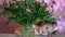 Child girl hides in a bouquet with peonies. Baby playing with pink peony flowers.