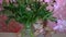 Child girl hides in a with peonies. Baby playing with pink peony flowers.