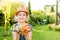 Child girl holding bunch of young carrots in the garden