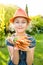 Child girl holding bunch of young carrots in the garden