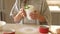 child girl holding cake in a mug, baking at home with kids, dessert preparation