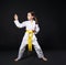 Child girl in karate suit with yellow belt show stance