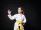 Child girl in karate suit with yellow belt show stance