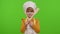 Child girl kid dressed as cook chef with fork and spatula, showing symbol of rejection, disagreement