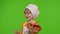 Child girl kid dressed as professional cook chef baker eating tasty strawberry pie on chroma key