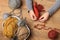 Child girl is learning to knit. Colorful wool yarns are on the wooden table. Hand closeup