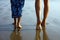 child and girl legs walking on the beach