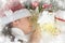child girl lie with candle lantern and dream, christmas decoration, face closeup, dressed in santa hat, winter holiday concept