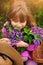 Child girl in lilac Garden. Girl smells the flowers, inhale the aroma in springtime. Gardening.