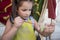 Child girl painting little clay piece with purple