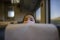 Child girl peeking out from behind a headrest train seat